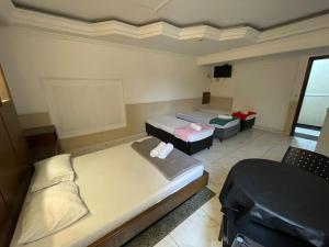 a room with two beds and a tv in it at Hotel Vitória de Santos in Santos