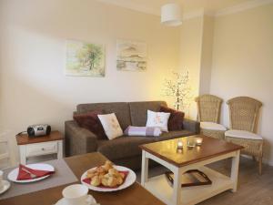 a living room with a couch and a table at Fischerweg-39-Whg-2-Amrum in Westerland +4 photos
