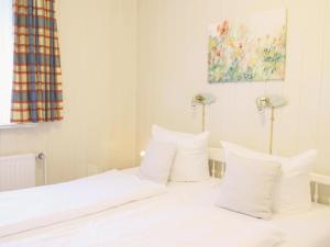 a bedroom with a bed with white sheets and pillows at Fischerweg-39-Whg-2-Amrum in Westerland