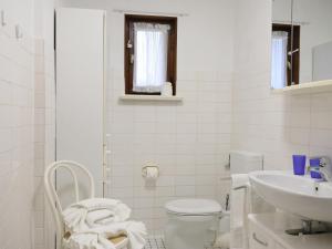 a white bathroom with a toilet and a sink at Fischerweg-39-Whg-2-Amrum in Westerland