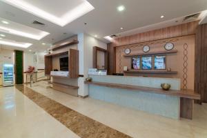 a lobby with a reception counter and clocks on the wall at Sidra Serviced Apartments - سدرا للشقق المخدومة in Al Khobar