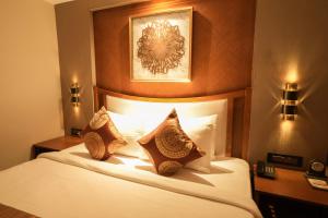 a hotel room with a bed with two pillows at Raj Regent Manarcadu in Kanjirapalli +82 photos