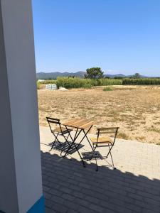 two chairs and a picnic table on a patio at A Quinta in Vila Nova de Milfontes