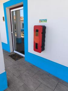 a red fire hydrant on the side of a building at A Quinta in Vila Nova de Milfontes