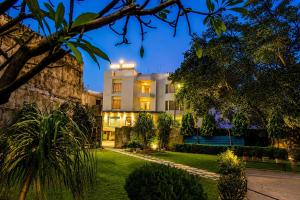 an exterior view of a building at night at Hotel Sainik Grand in Varanasi