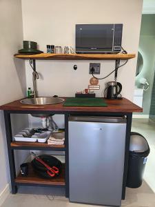 a desk with a microwave and a computer on it at Unit 8 Dinas Accommodation Oranjemund in Oranjemund +9 photos