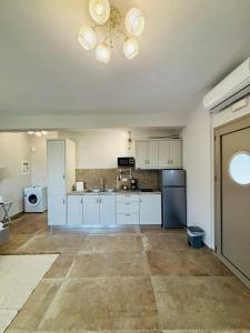 an empty kitchen with white cabinets and a blue refrigerator at Danita Apartments 3 in Paleros