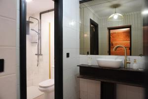 a bathroom with a sink and a toilet and a mirror at Loft Pedreña Studio in Pedreña