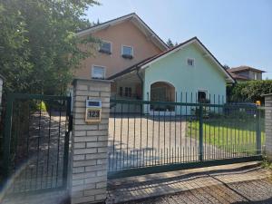 a fence in front of a house with a gate at Pension Eva in Domažlice