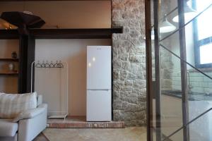 a refrigerator in a living room next to a stone wall at Loft Pedreña Studio in Pedreña