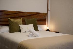a bedroom with a large white bed with green pillows at Loft Pedreña Studio in Pedreña