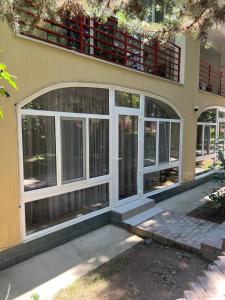 a building with large windows on the side of it at АпартаментРадугаВест1 in Koshkolʼ