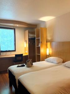 a hotel room with two beds and a window at Ibis Angers Centre Château in Angers +112 photos