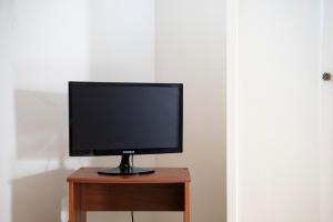 Ein Flachbildfernseher steht auf einem Holztisch. in der Unterkunft Db Apartment in Giurdignano