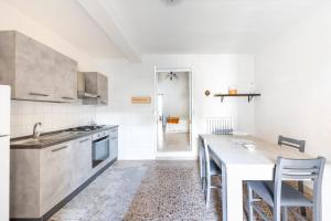 eine Küche mit einem Tisch und einigen Stühlen in der Unterkunft Db Apartment in Giurdignano