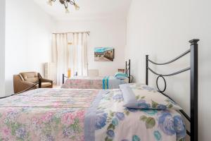 ein Schlafzimmer mit zwei Betten und einem Stuhl in der Unterkunft Db Apartment in Giurdignano