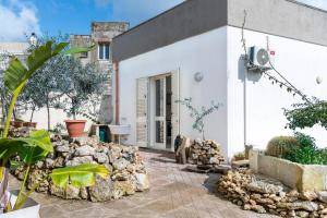 ein weißes Haus mit einem Steinhaufen davor in der Unterkunft Db Apartment in Giurdignano