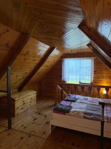 a bedroom with a bed in a wooden cabin at Domki Pod Lasem in Macharce