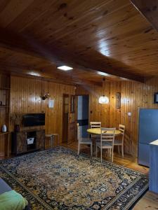 a dining room with wooden walls and a table and chairs at Domki Pod Lasem in Macharce