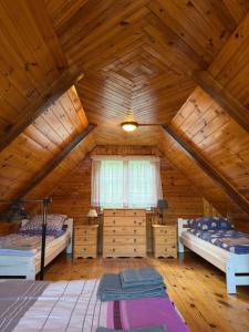a bedroom with two beds in a wooden attic at Domki Pod Lasem in Macharce +21 photos