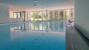 a large swimming pool in a building with a large window at Astoria (175 Cl) in Lenzerheide