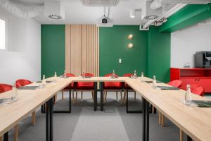 a conference room with a long table and red chairs at B&B HOTEL Kalisz Centrum in Kalisz