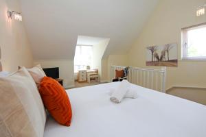 a bedroom with a white bed with orange and white pillows at Autumn Heights Apartments in Telford