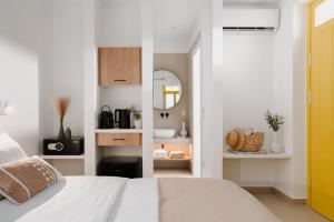 a white bedroom with a bed and a mirror at Asterry Suites in Kimolos +91 photos