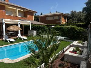 a backyard with a swimming pool and a house at Casa Rural El Olivo in Segovia