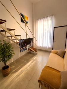 a living room with a couch and a tv at Loft Novo, Duplex, bem ventilado in Aparecida de Goiânia
