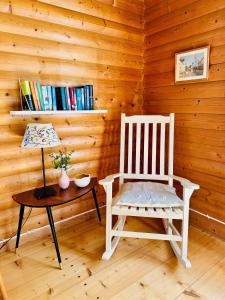 a room with a rocking chair and a table with a lamp at Haus Sommerlycka in Fågelfors