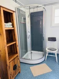 a glass shower in a room with a chair at Haus Sommerlycka in Fågelfors +39 photos