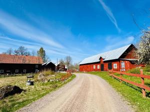a dirt road in front of a red barn at Haus Sommerlycka in Fågelfors