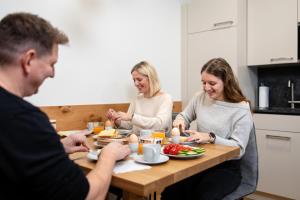 a group of people sitting around a table eating food at Ferienwohnung Königshofer in Neusiedl am See