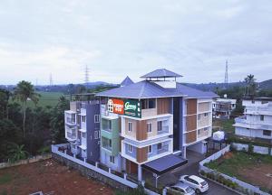 an apartment building with a sign on the top of it at Veedu and Co Greens in Cochin
