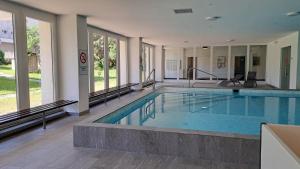 a large swimming pool in the middle of a building at Astoria (105 Sh) in Lenzerheide +18 photos