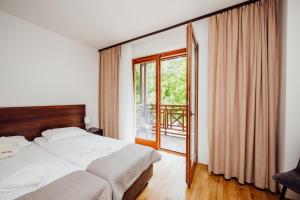ein Schlafzimmer mit einem Bett und einem großen Fenster in der Unterkunft Instytut Zdrowia Sofra FIT & SPA in Karpacz + 70 Fotos