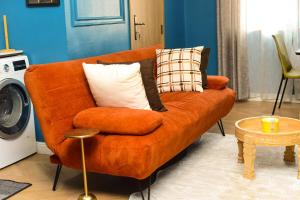 an orange couch with pillows in a living room at One Bedroom, Double bed and one sofa bed in Iseri