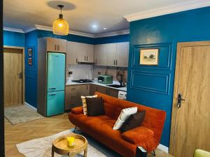 a living room with an orange couch and a kitchen at One Bedroom, Double bed and one sofa bed in Iseri