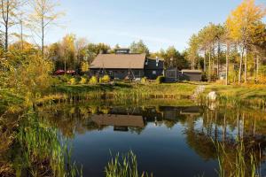 a house on a hill next to a lake at Hidden Pond Resort in Kennebunkport