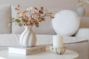 a table with a vase and a candle on it at Baltic Studio No 5 in Scharbeutz