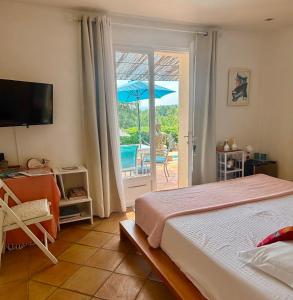 a bedroom with a bed and an open door to a patio at Villa des Delices in Grimaud +40 photos