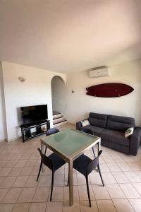 a living room with a couch and a table and chairs at Benni Surf House in San Pasquale