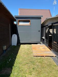a shed with a wooden ramp in a yard at Platin Pure in Jastarnia +4 photos