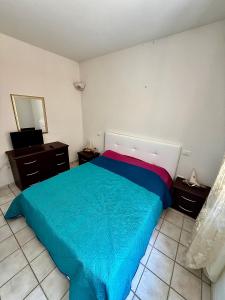 a bedroom with a blue bed and a mirror at Benni Surf House in San Pasquale