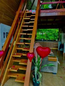 a wooden staircase with two red hearts in a vase at Chalé Paraíso in Nerópolis +5 photos