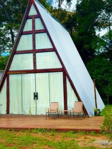 two chairs and a table in a triangular tent at Chalé Paraíso in Nerópolis