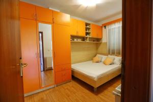 a small bedroom with orange cabinets and a bed at Holiday Home Rocca with pool in Vrgorac +58 photos
