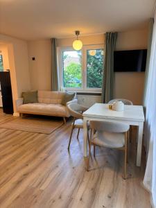 a living room with a table and a couch at Ruheoase am Stadtrand in Buchholz in der Nordheide