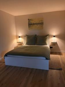 a bedroom with a large bed with two lamps at Ruheoase am Stadtrand in Buchholz in der Nordheide